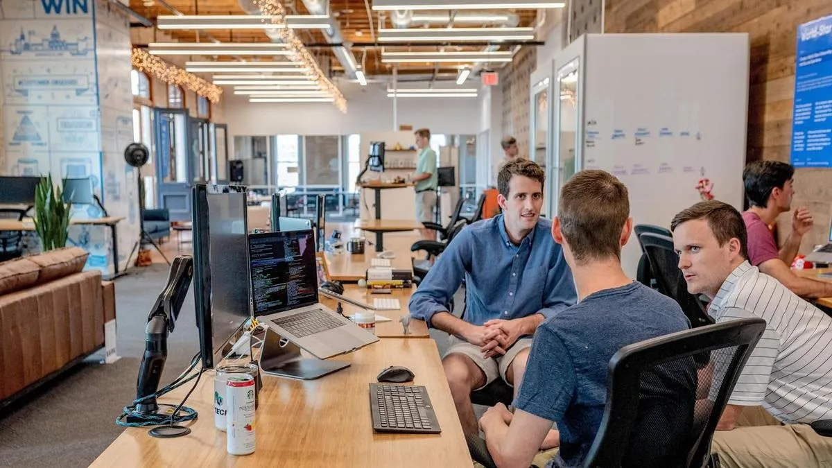 Engaged employees sitting in front of a desk discussing the company's strategy.