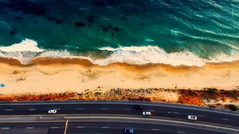 This is an image from Pexel of a beautiful coastline with cars on the road. This image iis great for use with digital signage software.