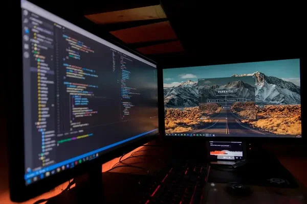 Two computer screens displaying code for developer digital signage.