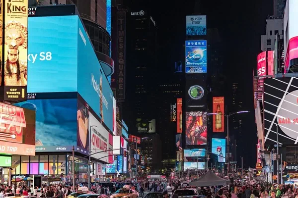 LED digital signs at night in a large square.